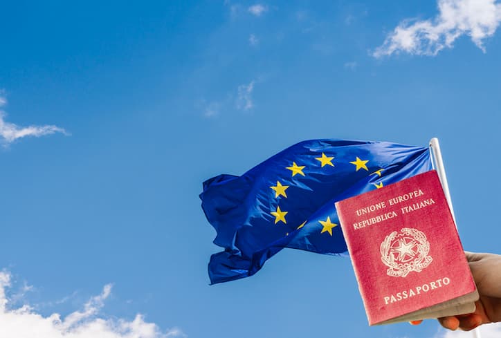 italian passport and flag with sky in the background
