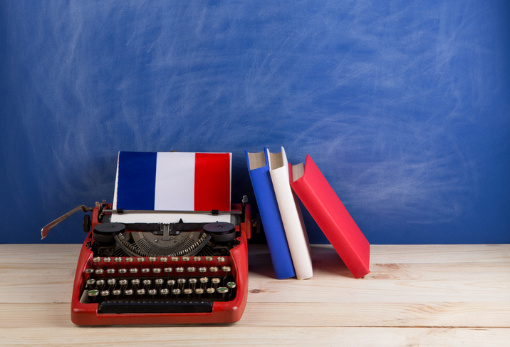  red typewriter, flag of the France, books on table